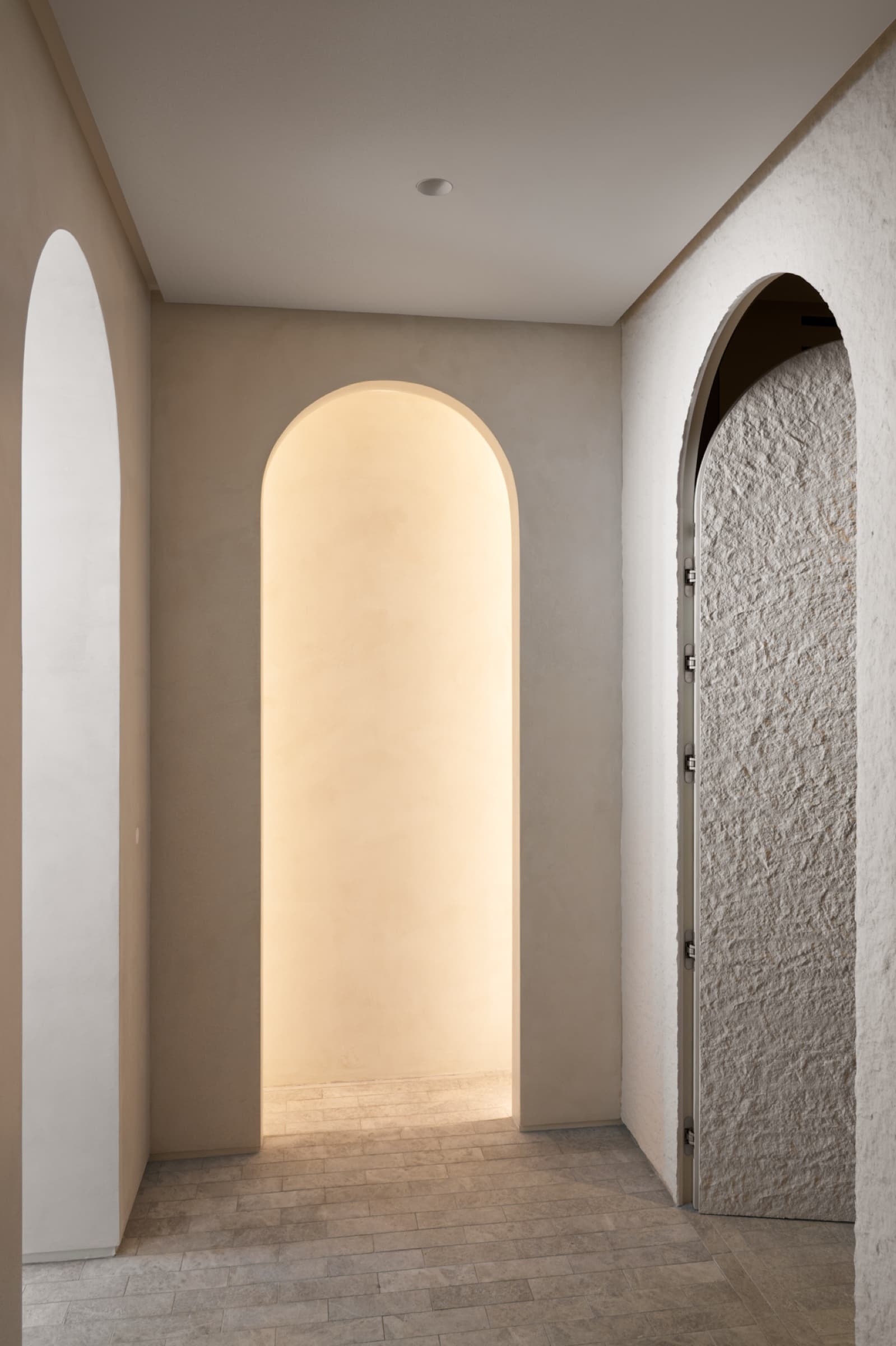 Hallway with illuminated arch and textured walls